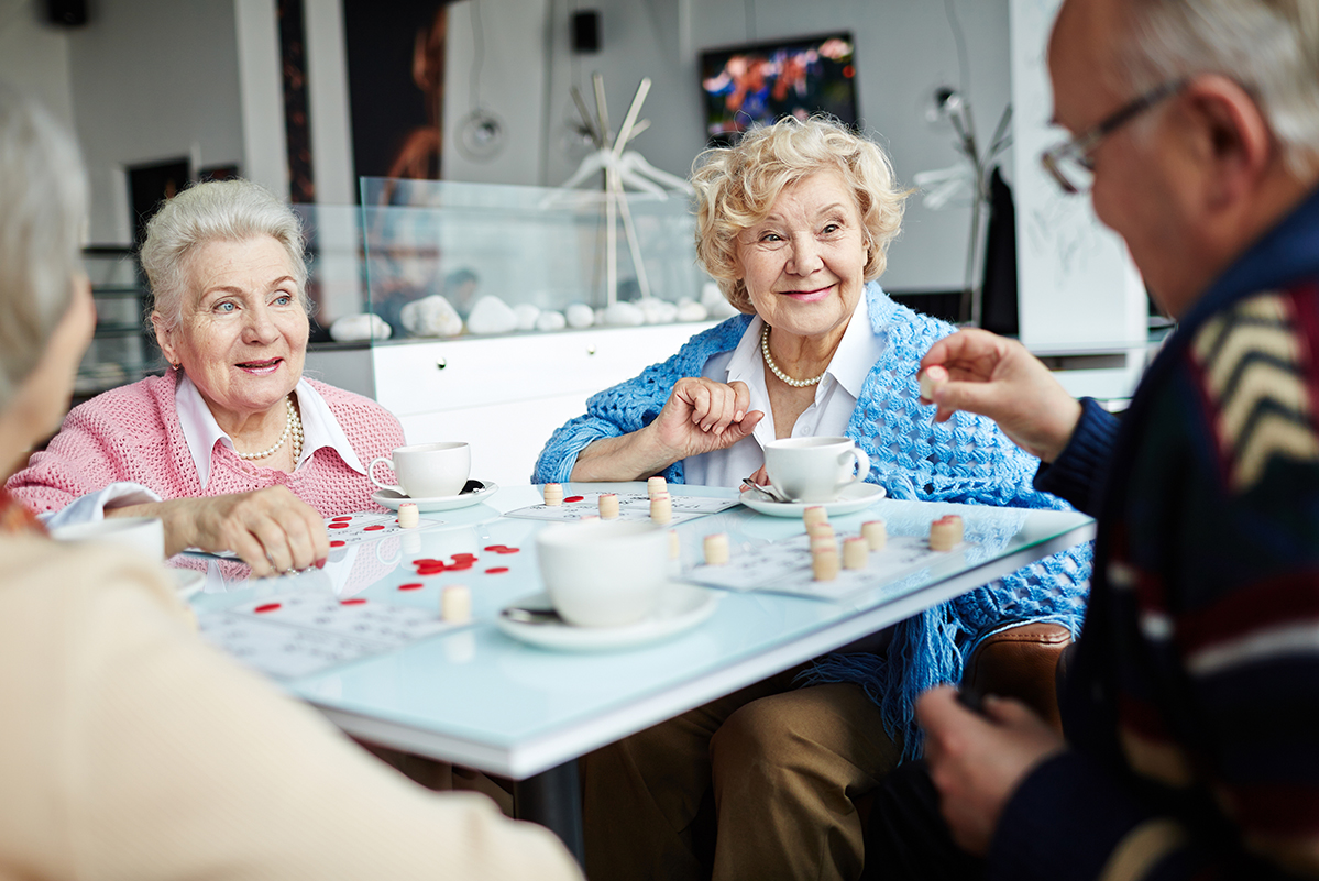 Elderly men and women playing games in a senior care facility