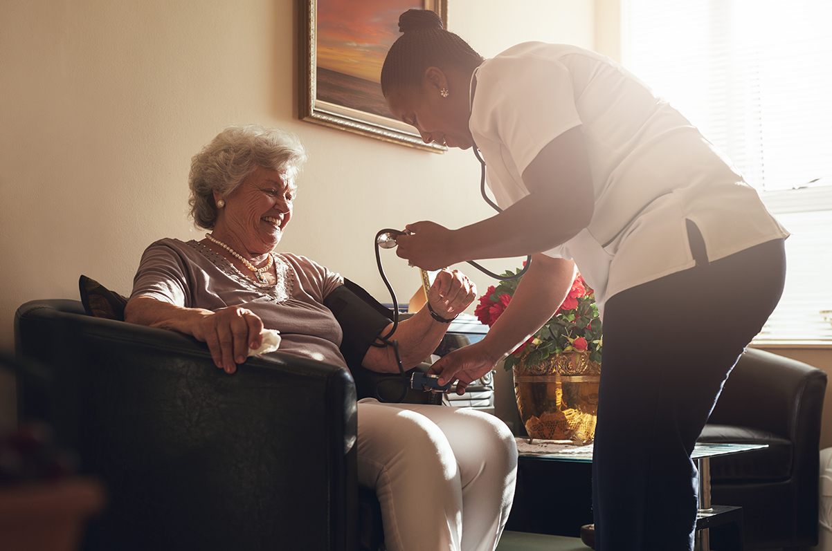 nurse measuring blood pressure of senior patient senior care at home