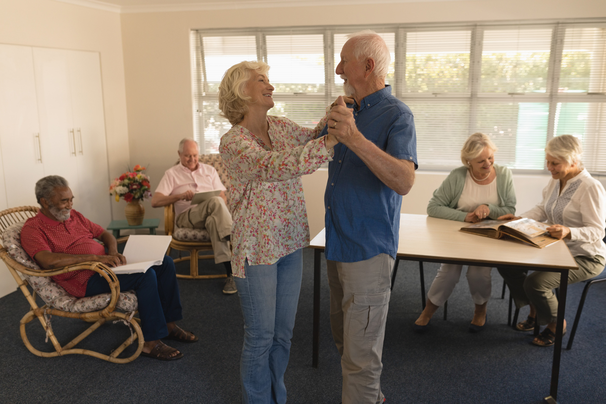 Active senior couple dancing in senior care facility